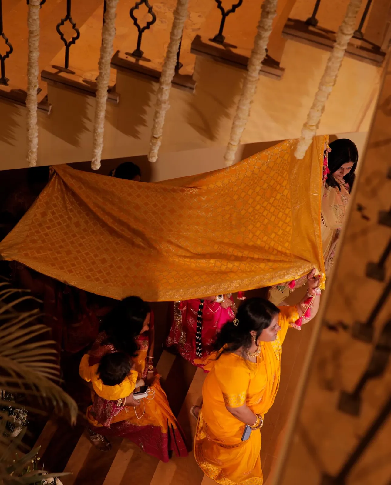 Bride arriving under a phoolon ki chadar canopy